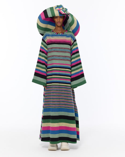 Model is wearing the Kimono Bouclé Multicolor Dress by Marrakshi Life, a hand-woven striped cotton bouclé dress with vibrant colors and flowing kimono sleeves, curated in the House of Woven Stories selection.