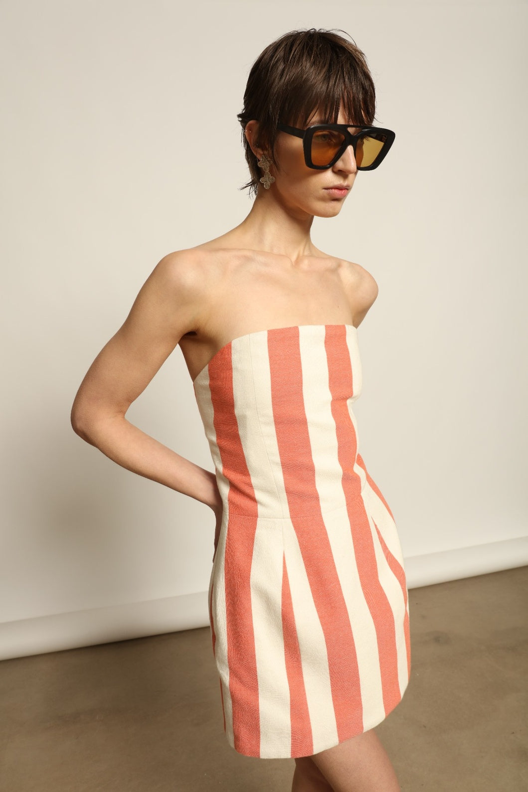 Model is wearing the Marrakshi Life Sculpted Corset Dress handmade in 100% cotton, a strapless mini dress with handwoven Moroccan texture from the House of Nomad Stories selection.