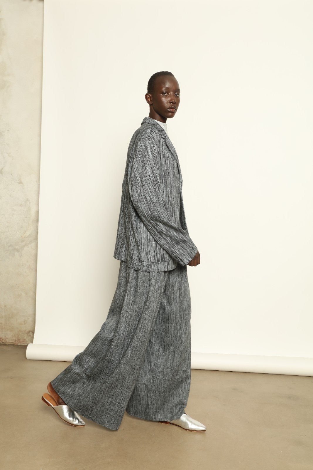 Model is wearing the Mid Rise Grey Chambray Pant by Marrakshi Life, part of House of Woven Stories collection, handwoven cotton wide-leg pants with relaxed fit and subtle textured chambray