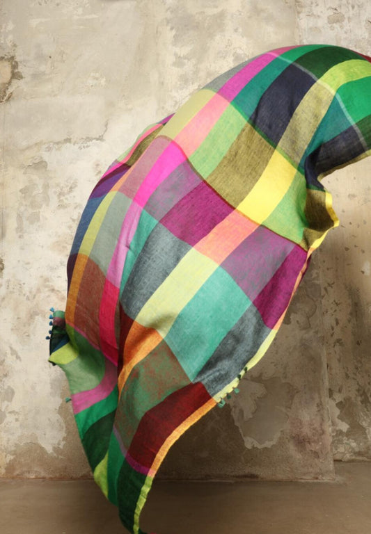 Model is wearing the Miraj 135 Cashmere Scarf by Injiri, handwoven from Himalayan cashmere with a multicolored Madras check and playful rounded borders, blending softness, warmth, and artisanal elegance.