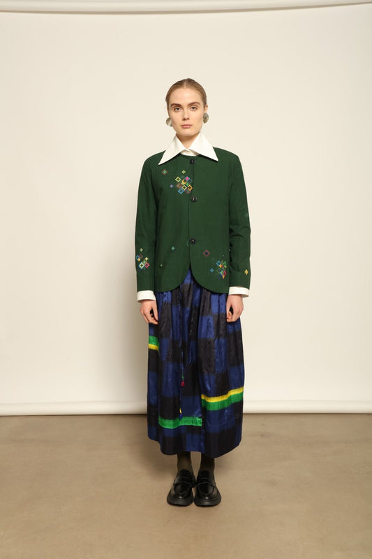 Model is wearing the Miraj 65 Cotton and Silk Jacket by Injiri, handwoven in deep green cotton and silk with geometric Jamdani motifs, blending Indian craftsmanship with contemporary elegance.