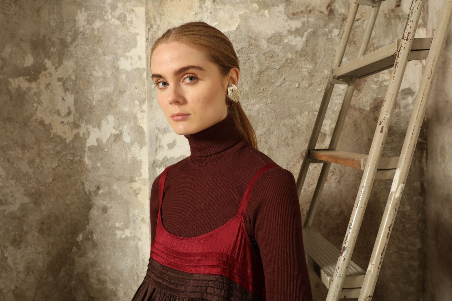 Model is wearing the Miraj 95 Silk and Cotton Slip Dress by Injiri, crafted in red and brown cotton with silk accents and a bold blue border, combining lightness, color, and refined craftsmanship.