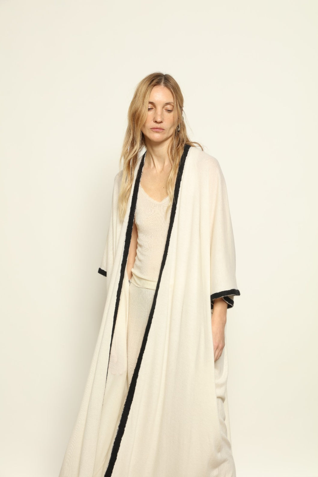 Model Nastia wearing the Natural White Long Cardigan by Mirror in the Sky, a handmade 100% cashmere long cardigan with flowing silhouette and natural undyed finish.