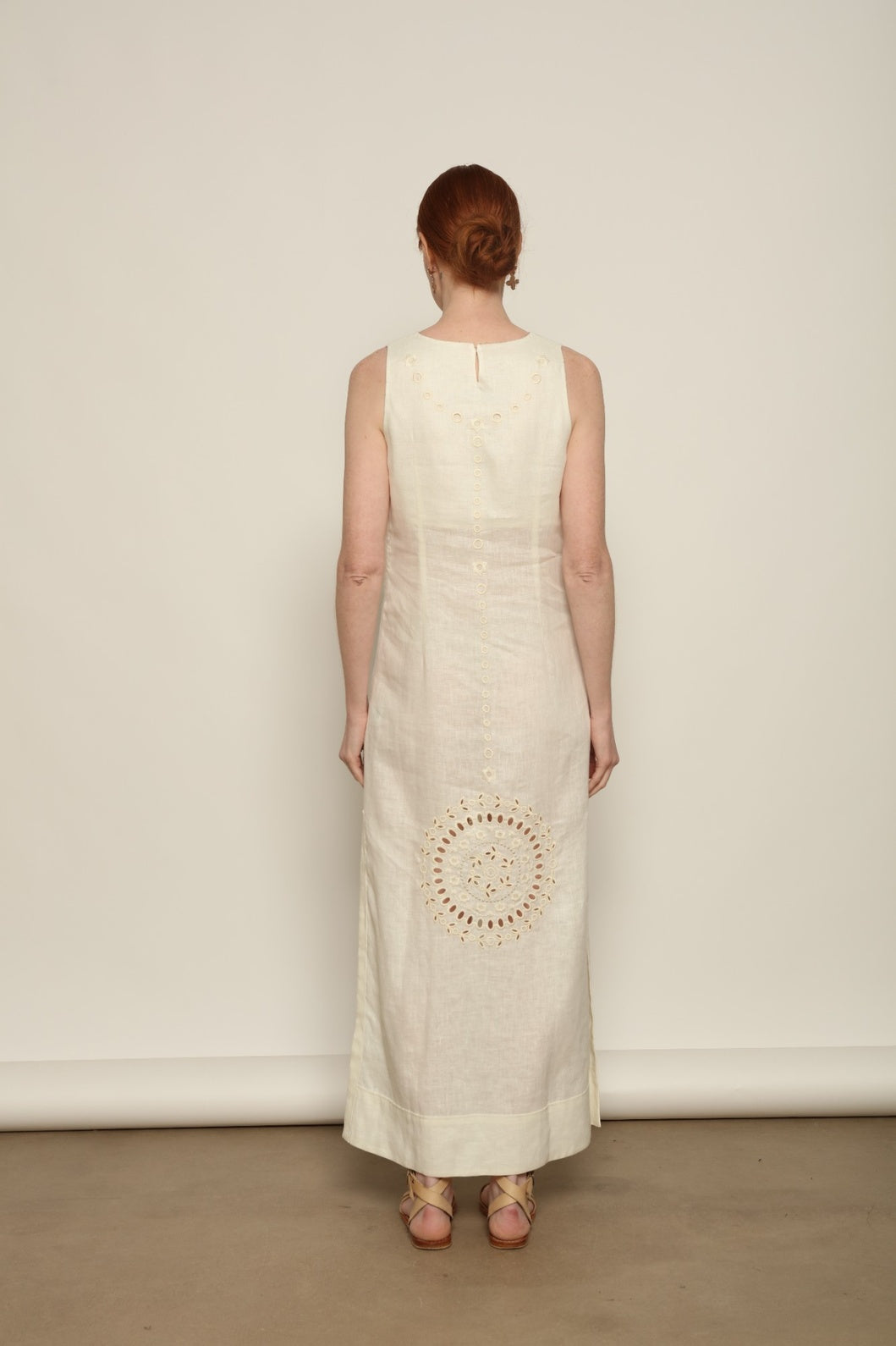 Model is wearing the My Sleeping Gypsy Champenois Dress, an ivory linen dress with hand-cut lace, delicate embroidery, and 24-carat bead accents, from the House of Nomad Stories selection.