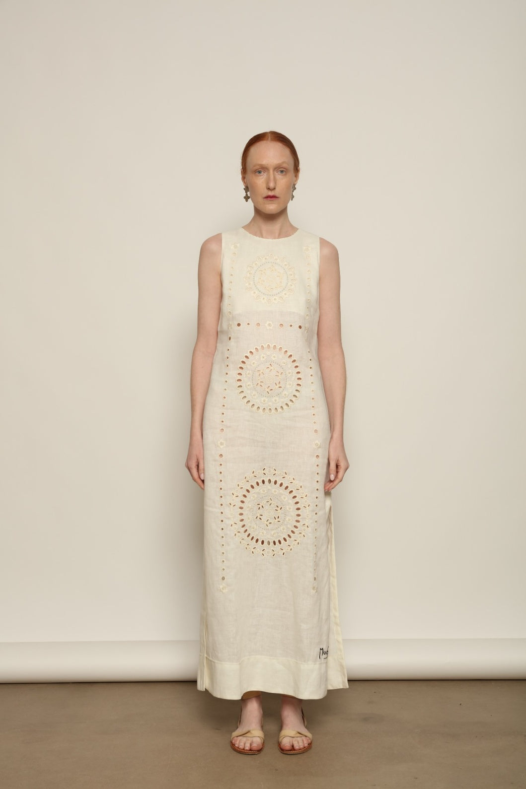 Model is wearing the My Sleeping Gypsy Champenois Dress, an ivory linen dress with hand-cut lace, delicate embroidery, and 24-carat bead accents, from the House of Nomad Stories selection.