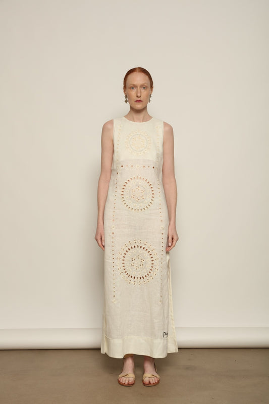 Model is wearing the My Sleeping Gypsy Champenois Dress, an ivory linen dress with hand-cut lace, delicate embroidery, and 24-carat bead accents, from the House of Nomad Stories selection.