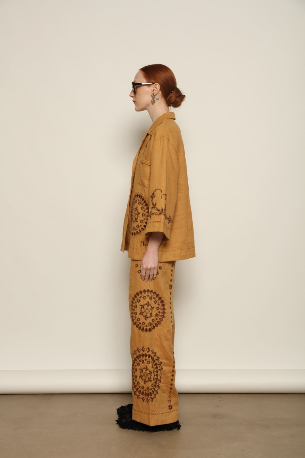 Model is wearing the My Sleeping Gypsy Sarah Jacket, an ivory linen jacket with hand-cut lace, intricate embroidery, and 24-carat bead accents, from the House of Nomad Stories selection.