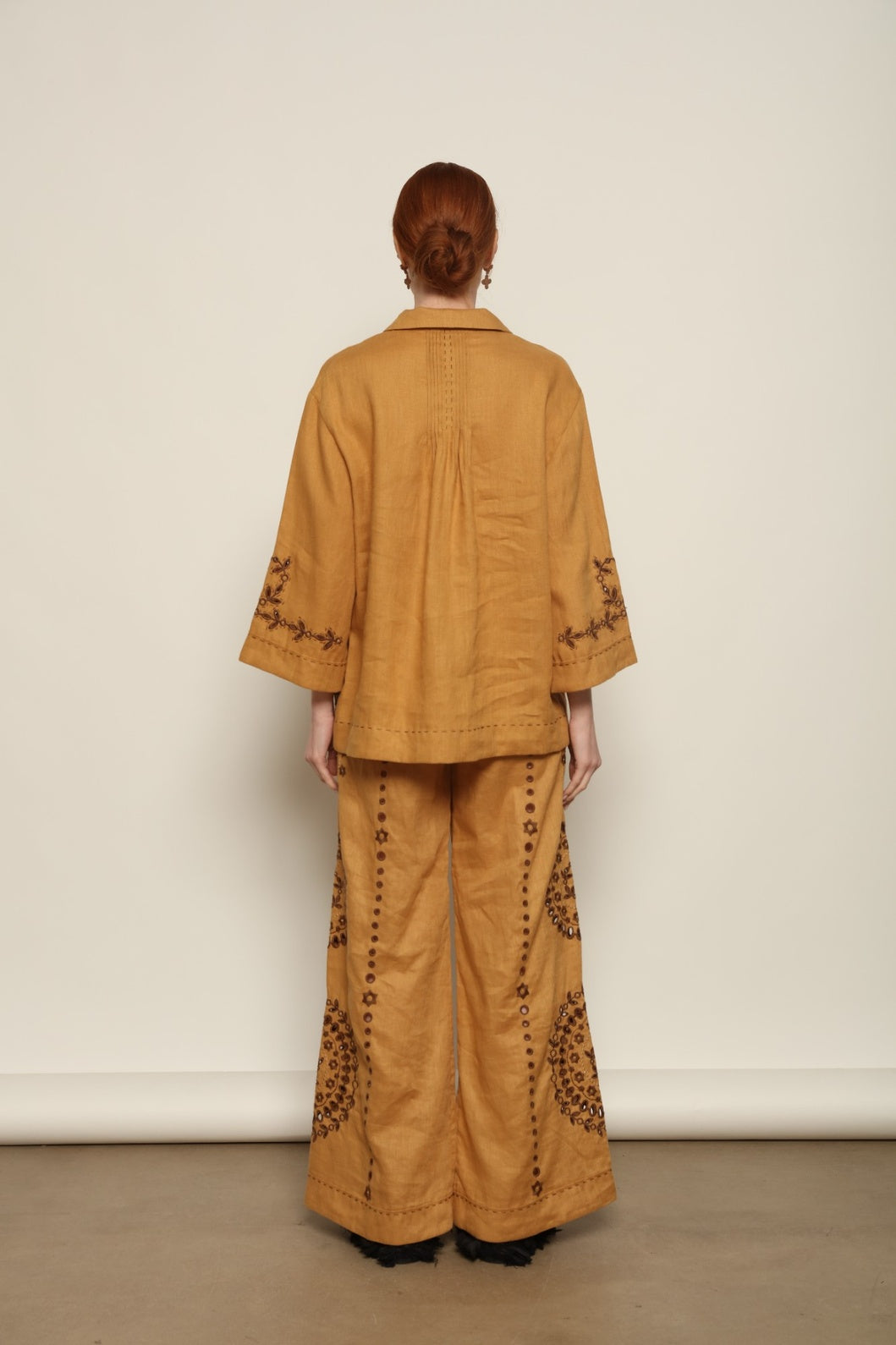 Model is wearing the My Sleeping Gypsy Sarah Jacket, an ivory linen jacket with hand-cut lace, intricate embroidery, and 24-carat bead accents, from the House of Nomad Stories selection.