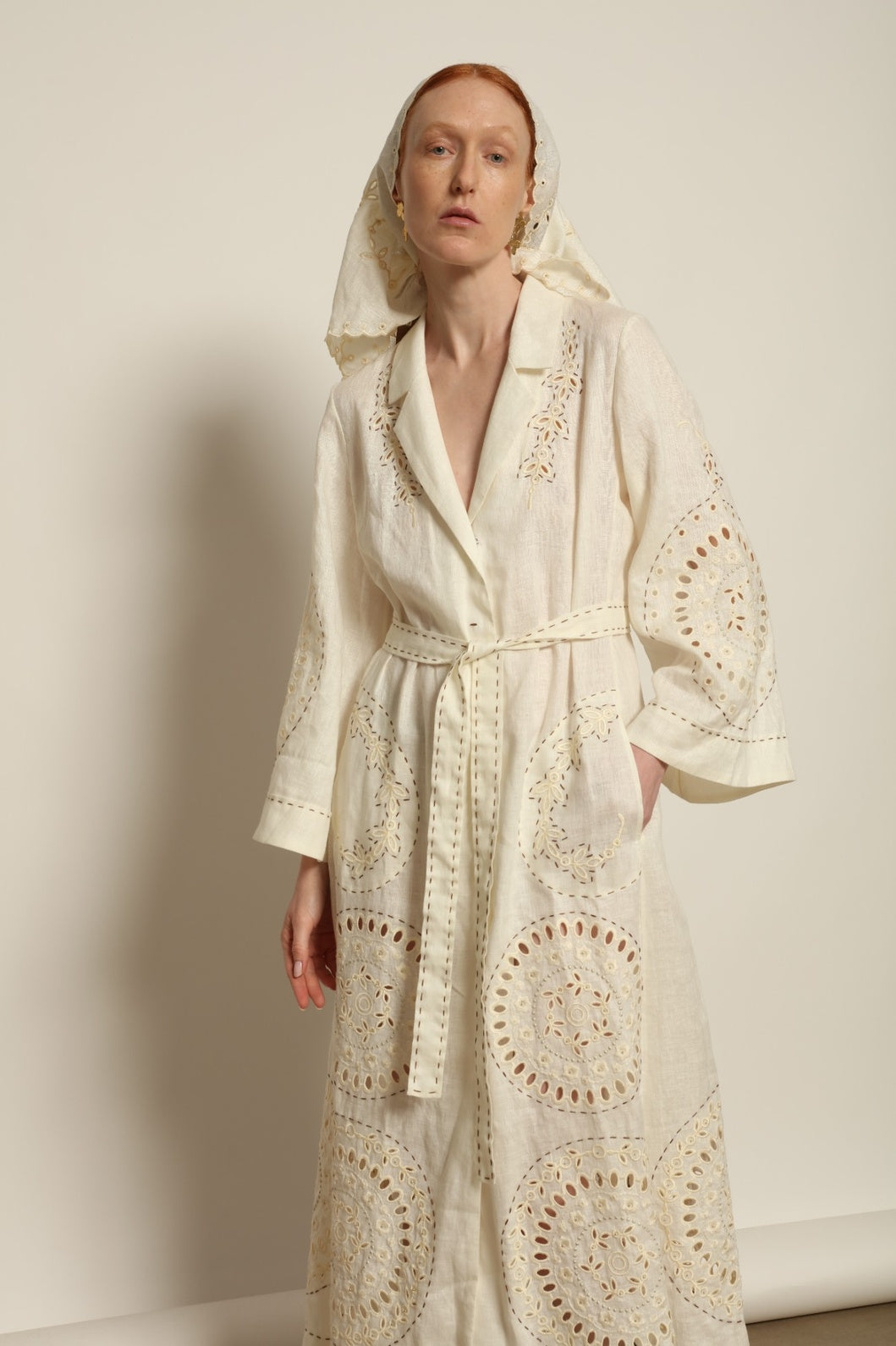 Model is wearing the My Sleeping Gypsy Sarah Long Dress in Ivory, handcrafted from linen with delicate lace, embroidery, and 24-carat bead accents, from the House of Nomad Stories selection.