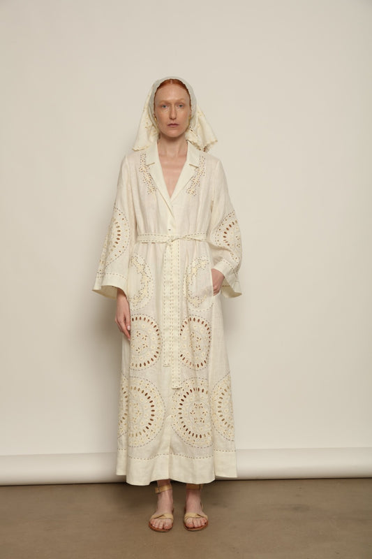 Model is wearing the My Sleeping Gypsy Sarah Long Dress in Ivory, handcrafted from linen with delicate lace, embroidery, and 24-carat bead accents, from the House of Nomad Stories selection.