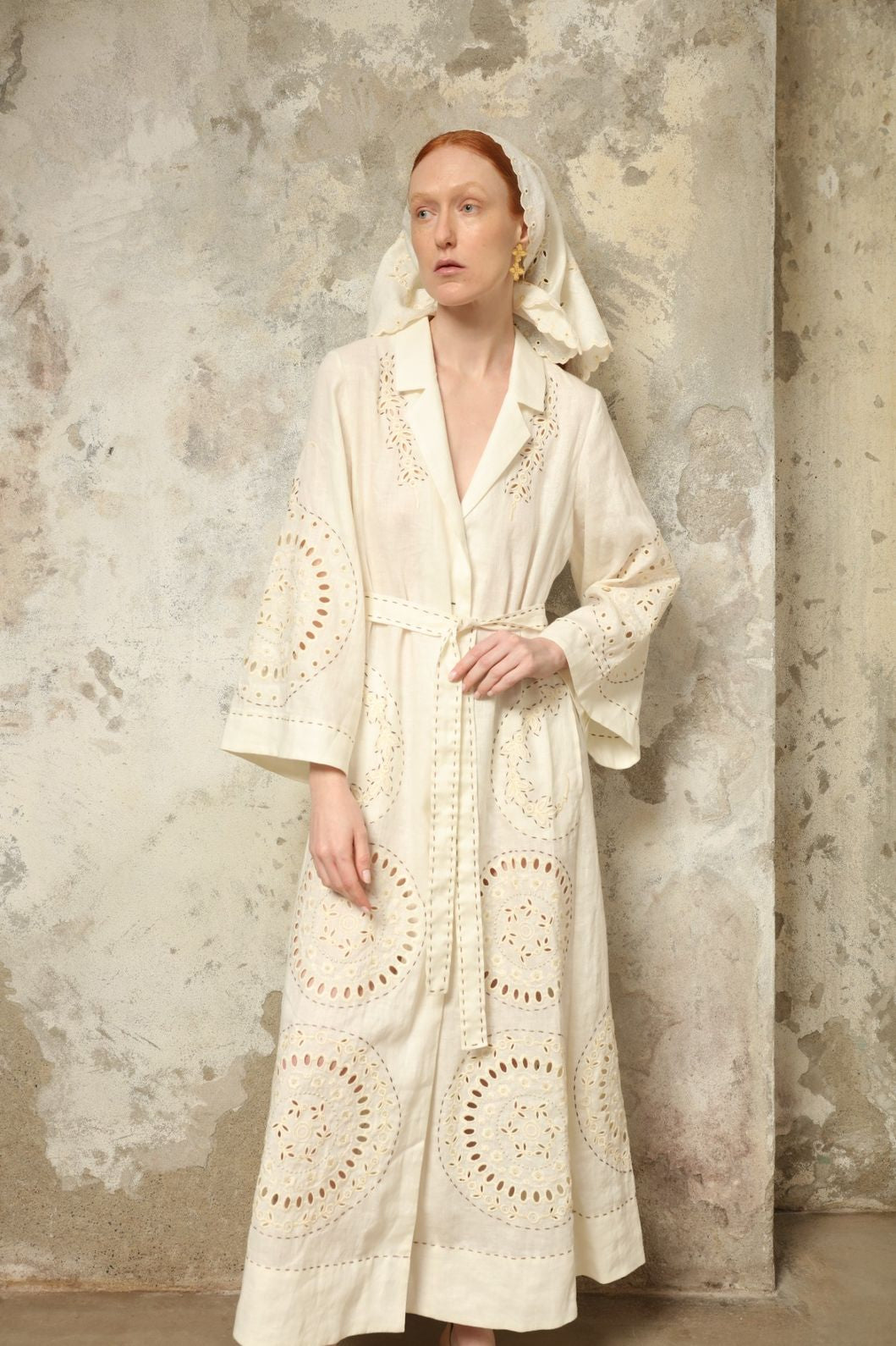 Model is wearing the My Sleeping Gypsy Sarah Long Dress in Ivory, handcrafted from linen with delicate lace, embroidery, and 24-carat bead accents, from the House of Nomad Stories selection.