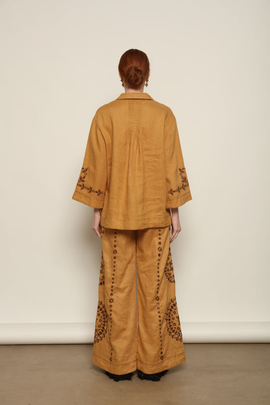 Model is wearing the My Sleeping Gypsy Sarah Pants, high-waisted 100% linen trousers with handmade lace, tonal embroidery, and 24-carat bead accents, from the House of Nomad Stories selection.