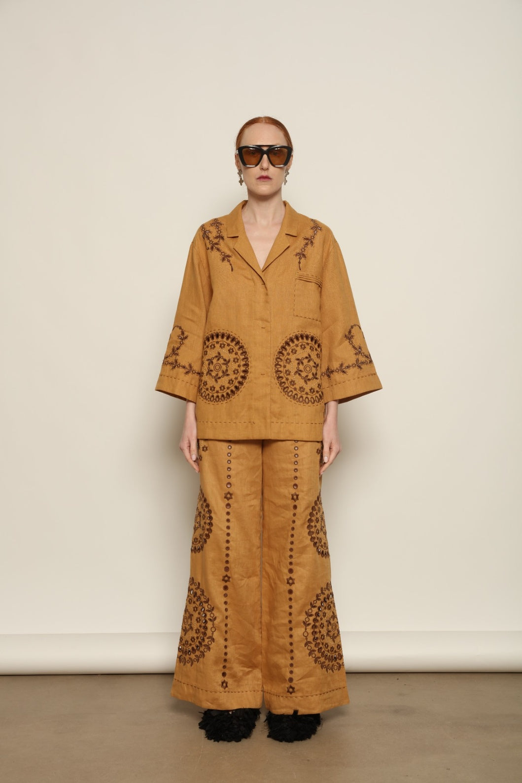 Model is wearing the My Sleeping Gypsy Sarah Pants, high-waisted 100% linen trousers with handmade lace, tonal embroidery, and 24-carat bead accents, from the House of Nomad Stories selection.