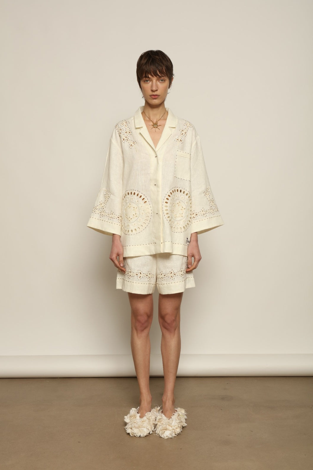 Model is wearing the My Sleeping Gypsy Sarah Suit, a handcrafted ivory linen set with high-waisted shorts, relaxed jacket, intricate embroidery, and 24-carat bead accents, from the House of Nomad Stories selection.