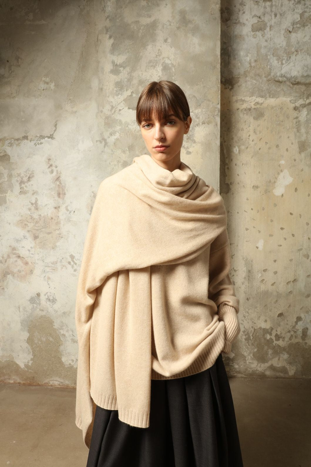Model wearing the Natural Leni Cashmere Scarf by House of Woven Stories, made from 100% pure Inner Mongolia cashmere, featuring a soft natural shade, lightweight drape, smooth texture, lasting warmth, and ethical sustainable craftsmanship