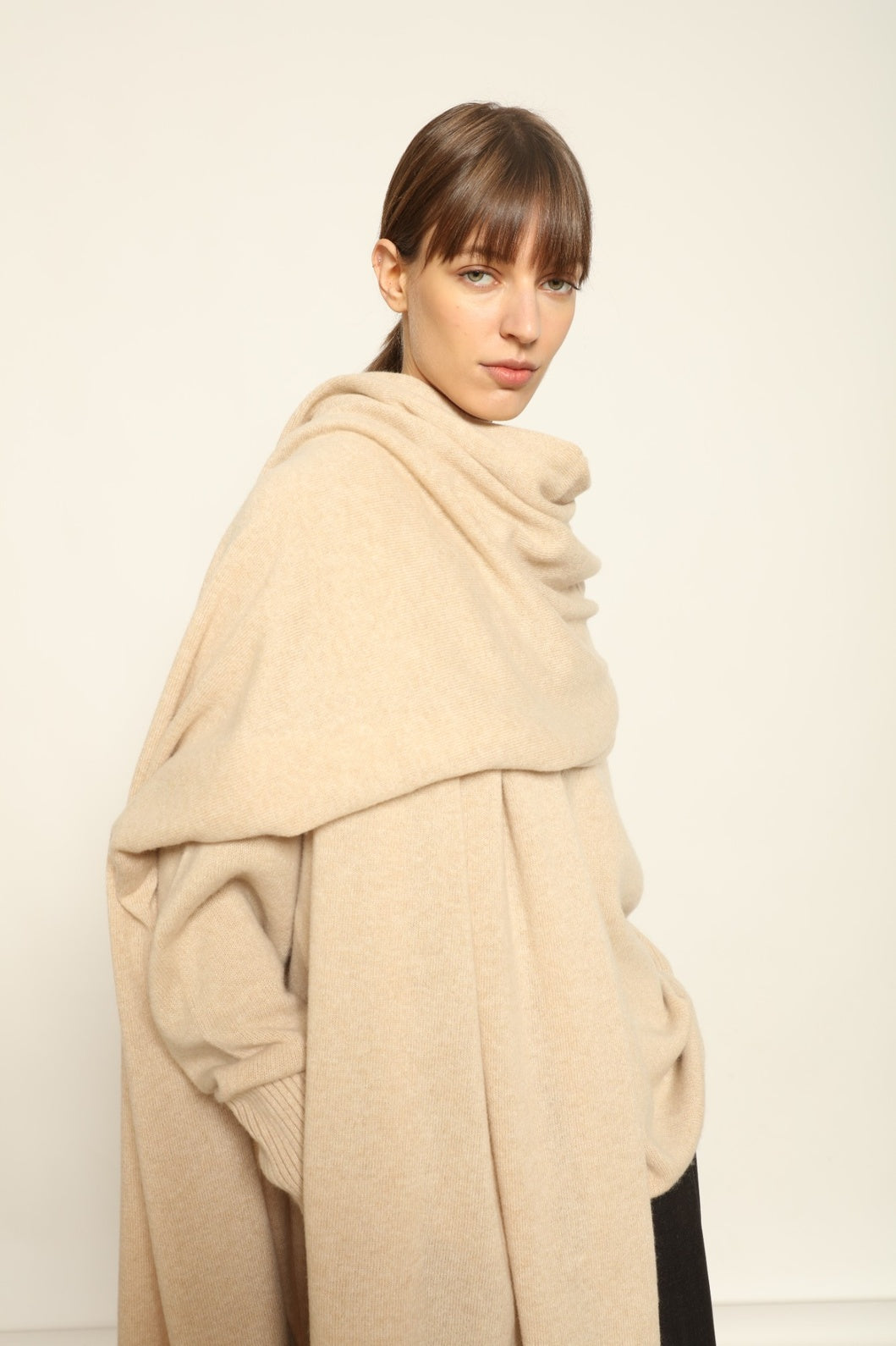 Model wearing the Natural Leni Cashmere Scarf by House of Woven Stories, made from 100% pure Inner Mongolia cashmere, featuring a soft natural shade, lightweight drape, smooth texture, lasting warmth, and ethical sustainable craftsmanship