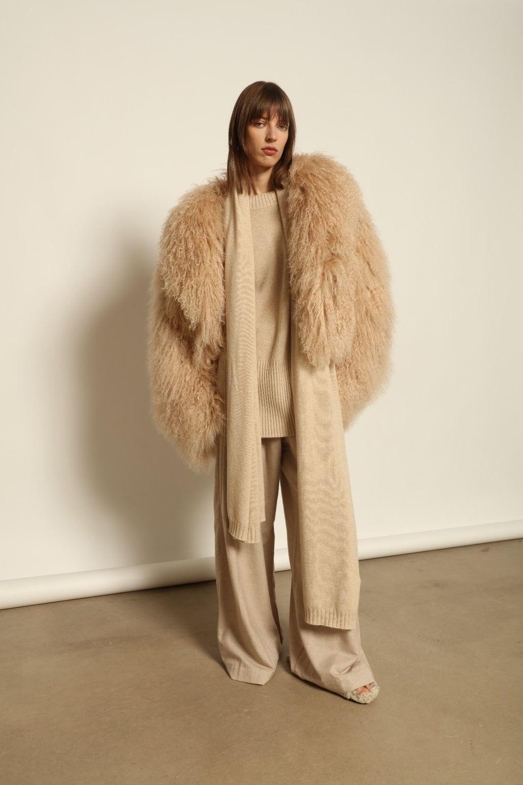 Model wearing the Natural Leni Cashmere Scarf by House of Woven Stories, made from 100% pure Inner Mongolia cashmere, featuring a soft natural shade, lightweight drape, smooth texture, lasting warmth, and ethical sustainable craftsmanship