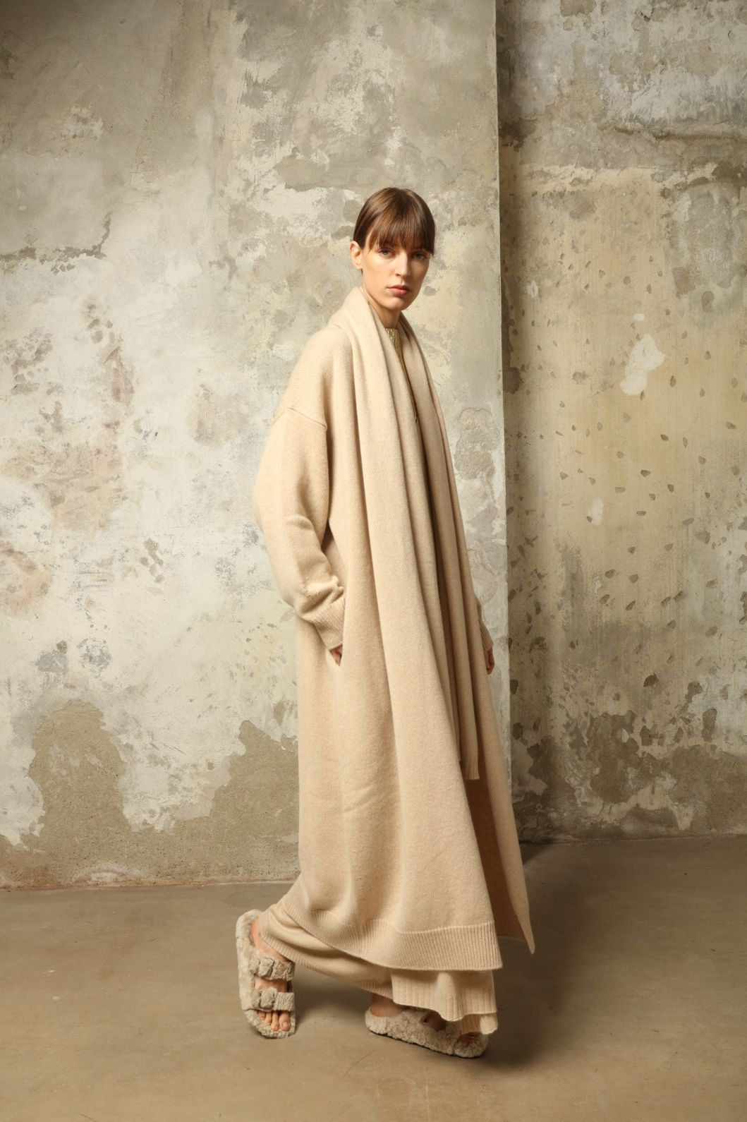 Model wearing the Natural Paula Cashmere Coat by House of Woven Stories, made from 100% pure Inner Mongolia cashmere, featuring a soft natural shade, open-front design, elegant drape, cozy warmth, and sustainable, ethically crafted luxury