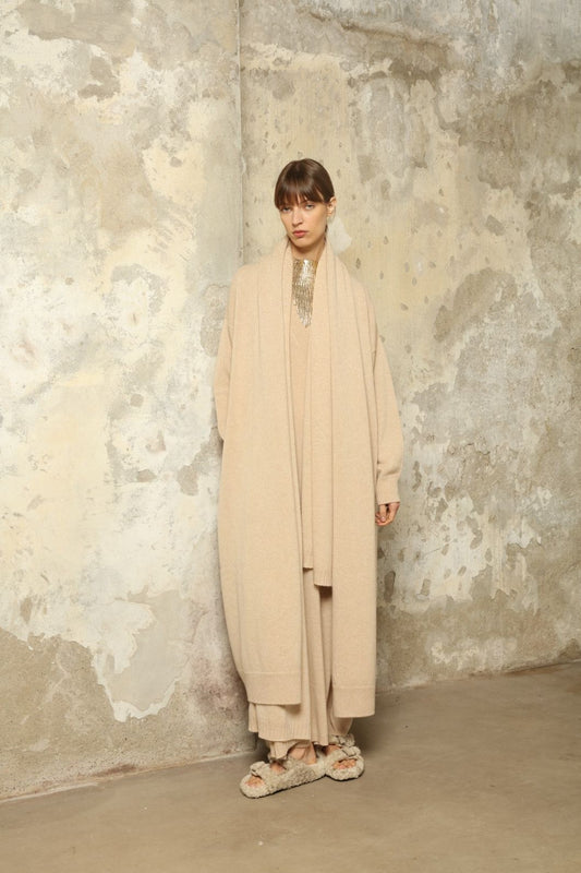 Model wearing the Natural Paula Cashmere Coat by House of Woven Stories, made from 100% pure Inner Mongolia cashmere, featuring a soft natural shade, open-front design, elegant drape, cozy warmth, and sustainable, ethically crafted luxury