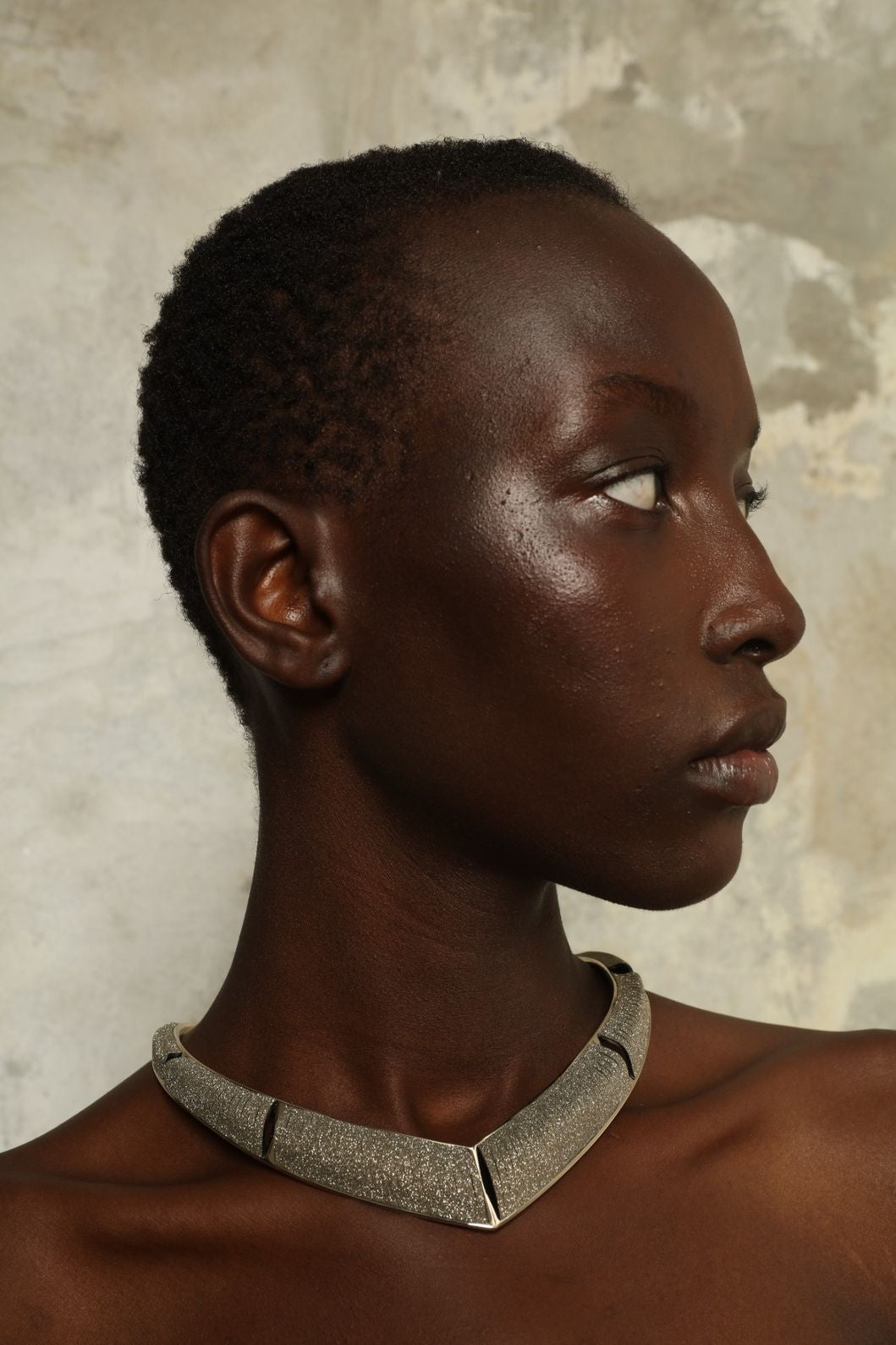Model is wearing Nemesi Crystal Silver Leather Necklace by SO-LE STUDIO, a handcrafted upcycled Italian leather piece with crystal-infused silver surface, featuring fluid, architectural lines and a lightweight, structured design.