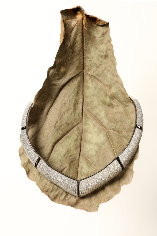 Model is wearing Nemesi Crystal Silver Leather Necklace by SO-LE STUDIO, a handcrafted upcycled Italian leather piece with crystal-infused silver surface, featuring fluid, architectural lines and a lightweight, structured design.