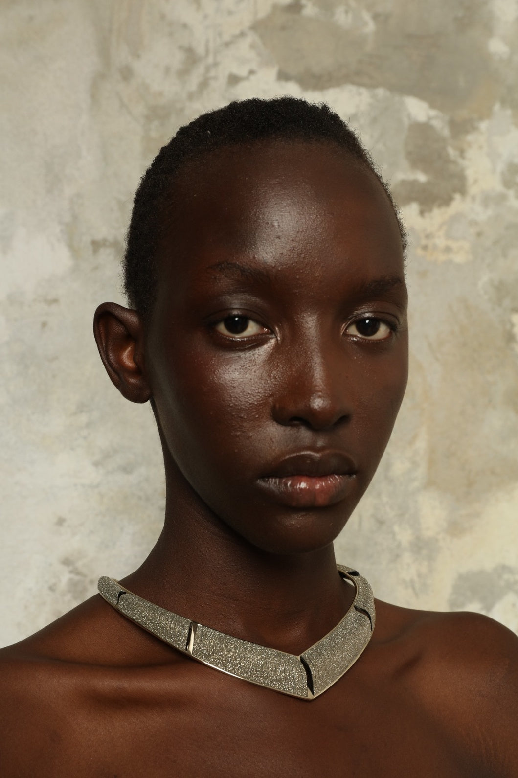 Model is wearing Nemesi Crystal Silver Leather Necklace by SO-LE STUDIO, a handcrafted upcycled Italian leather piece with crystal-infused silver surface, featuring fluid, architectural lines and a lightweight, structured design.