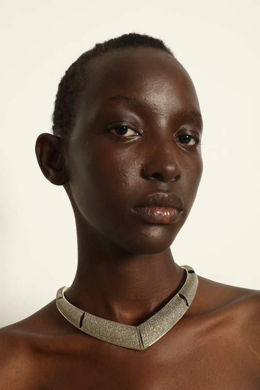Model is wearing Nemesi Crystal Silver Leather Necklace by SO-LE STUDIO, a handcrafted upcycled Italian leather piece with crystal-infused silver surface, featuring fluid, architectural lines and a lightweight, structured design.