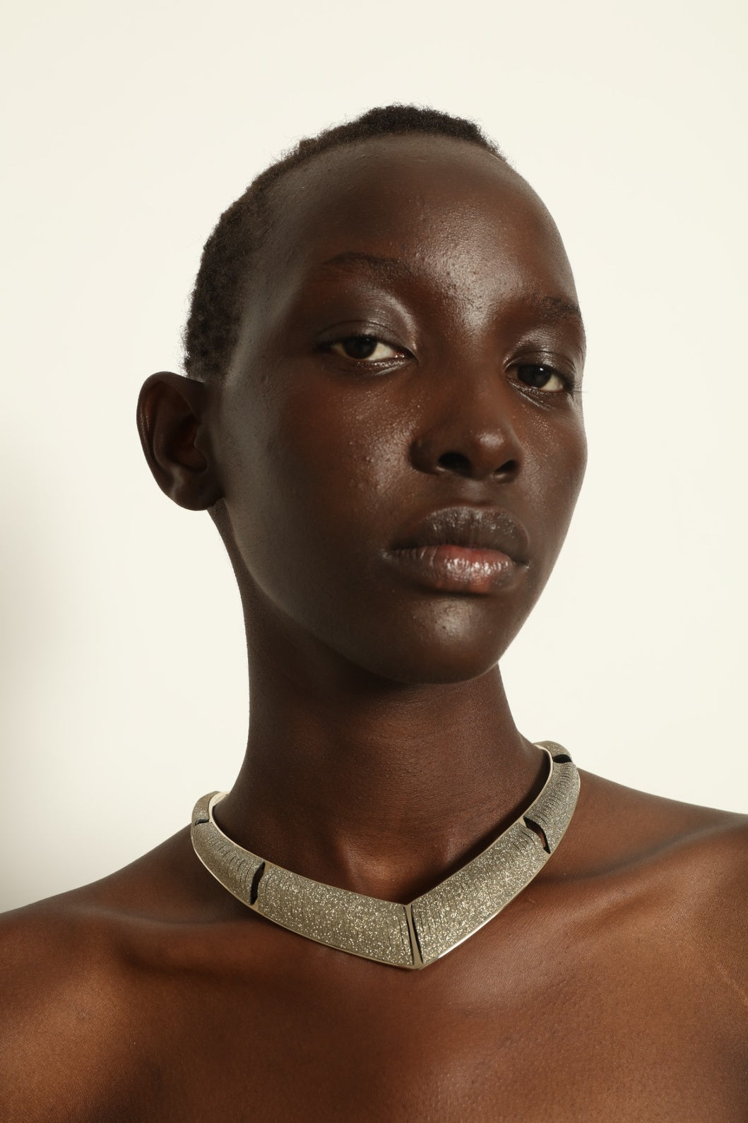 Model is wearing Nemesi Crystal Silver Leather Necklace by SO-LE STUDIO, a handcrafted upcycled Italian leather piece with crystal-infused silver surface, featuring fluid, architectural lines and a lightweight, structured design.