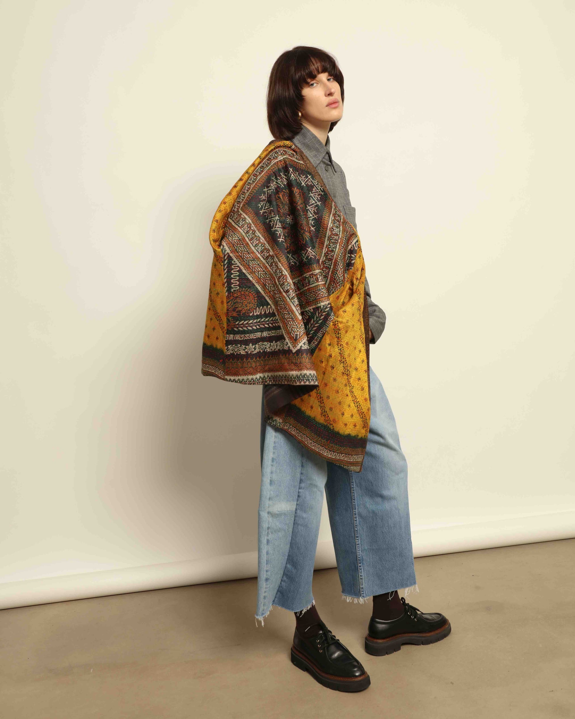 Model is wearing the Obidi Checked Kantha Jacket in wool and silk, with a silk collar and unique printed silk lining, a one-of-a-kind artisanal piece. Part of House of Woven Stories selection.