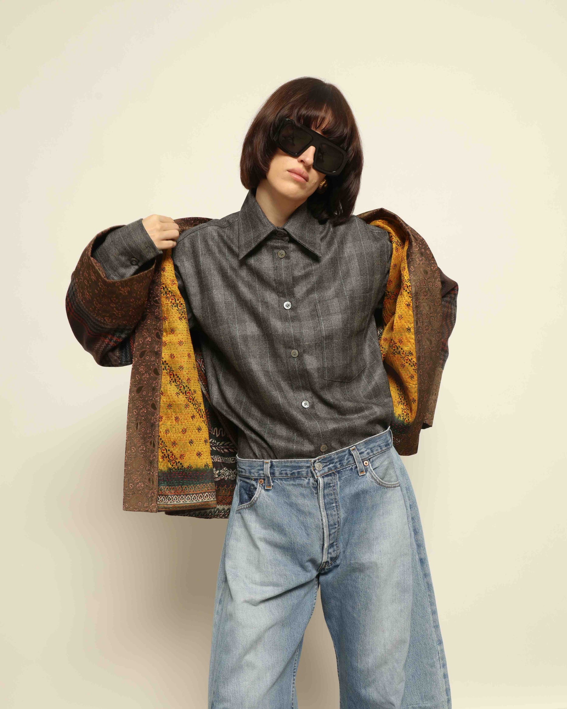 Model is wearing the Obidi Checked Kantha Jacket in wool and silk, with a silk collar and unique printed silk lining, a one-of-a-kind artisanal piece. Part of House of Woven Stories selection.