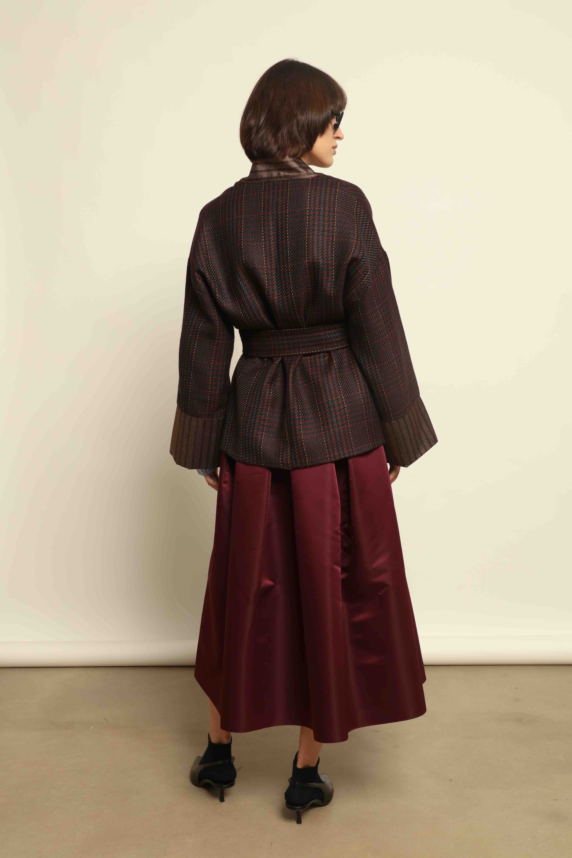Model is wearing the Obidi Checked Kantha Jacket in wool and silk with a refined silk collar and unique printed silk lining, crafted with artisanal Kantha technique. Part of House of Woven Stories selection.
