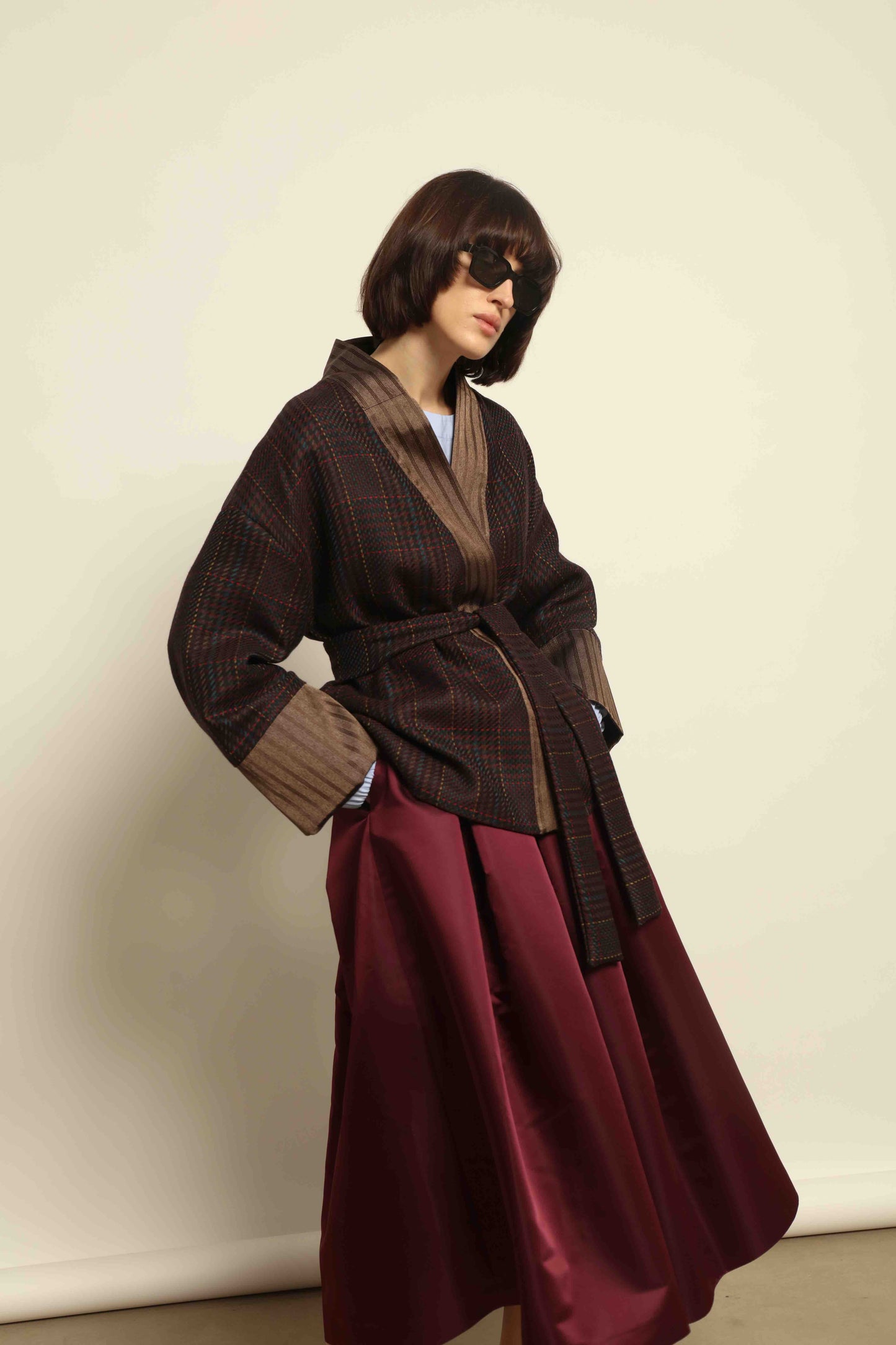 Model is wearing the Obidi Checked Kantha Jacket in wool and silk with a refined silk collar and unique printed silk lining, crafted with artisanal Kantha technique. Part of House of Woven Stories selection.