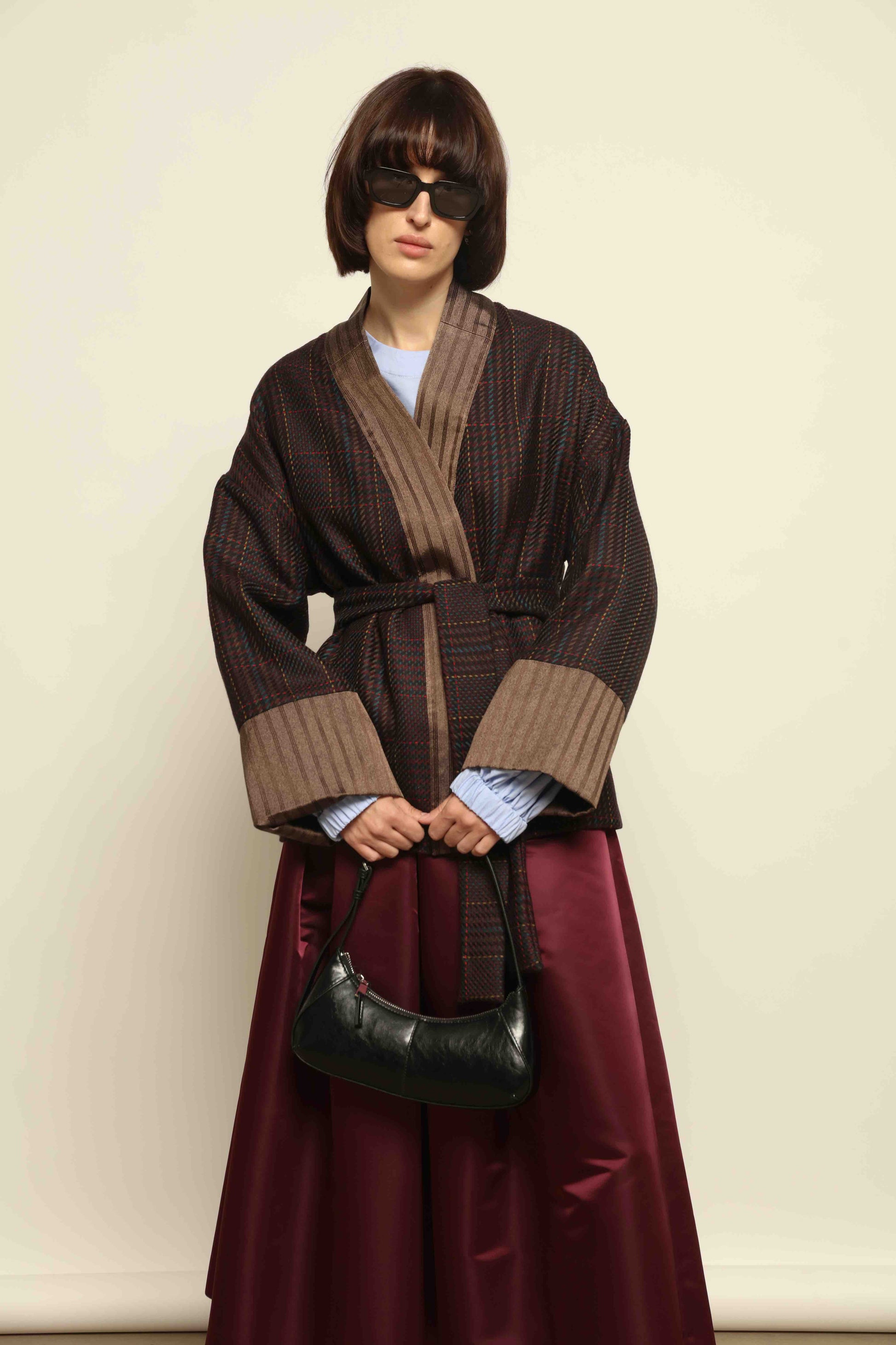 Model is wearing the Obidi Checked Kantha Jacket in wool and silk with a refined silk collar and unique printed silk lining, crafted with artisanal Kantha technique. Part of House of Woven Stories selection.