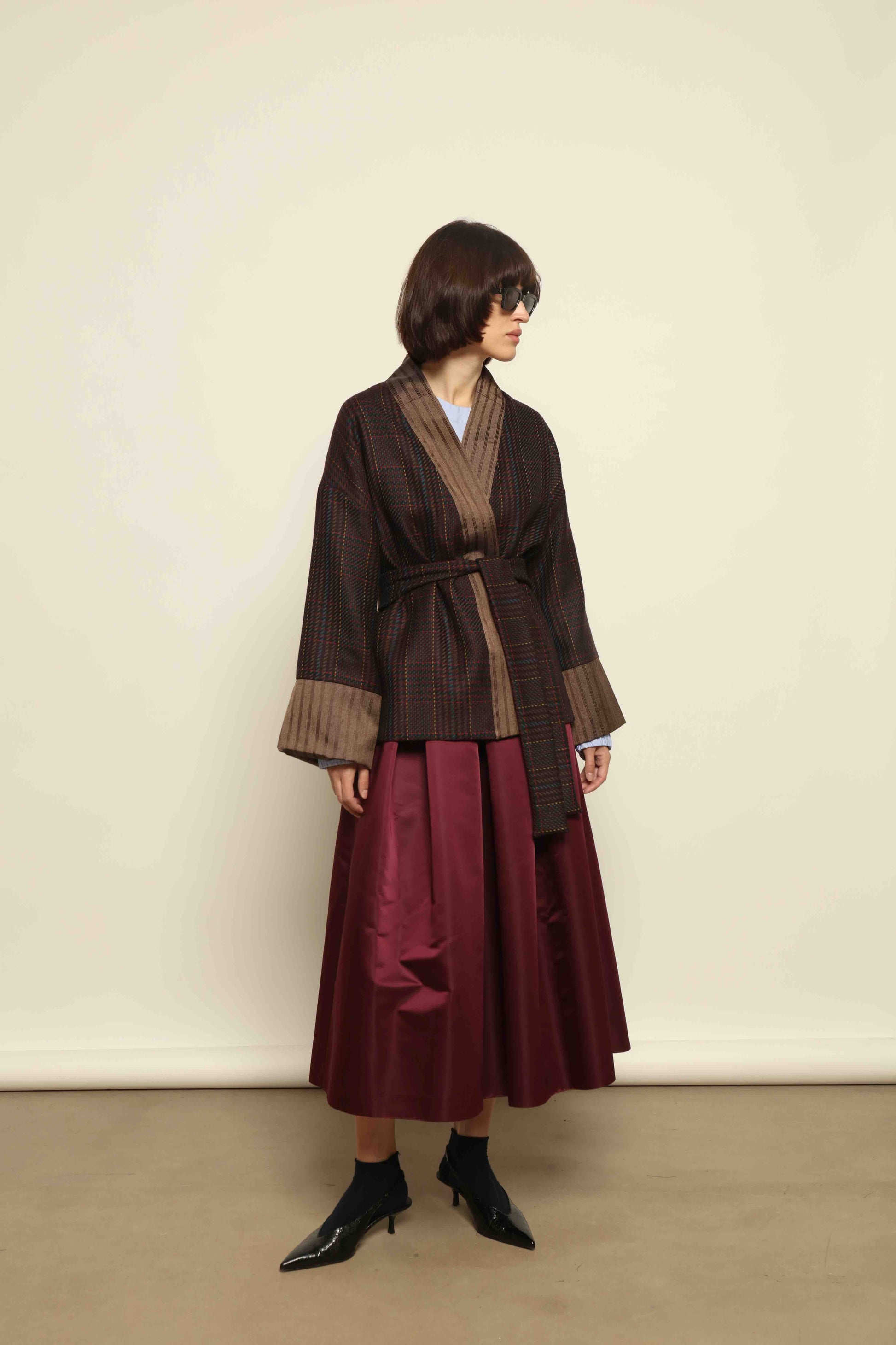 Model is wearing the Obidi Checked Kantha Jacket in wool and silk with a refined silk collar and unique printed silk lining, crafted with artisanal Kantha technique. Part of House of Woven Stories selection.