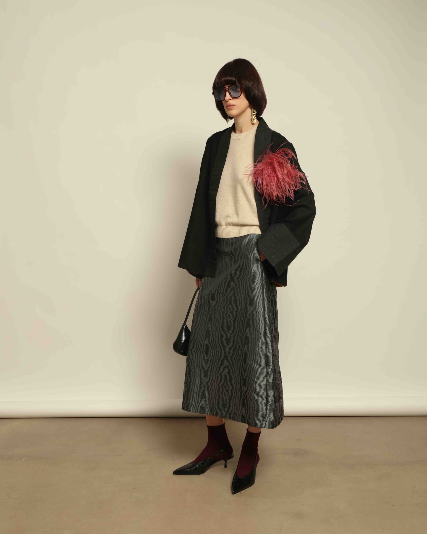 The model is wearing the Obidi Midnight Kantha Jacket in pure black, made of wool with a silk collar and Kantha silk lining, a timeless and versatile piece.