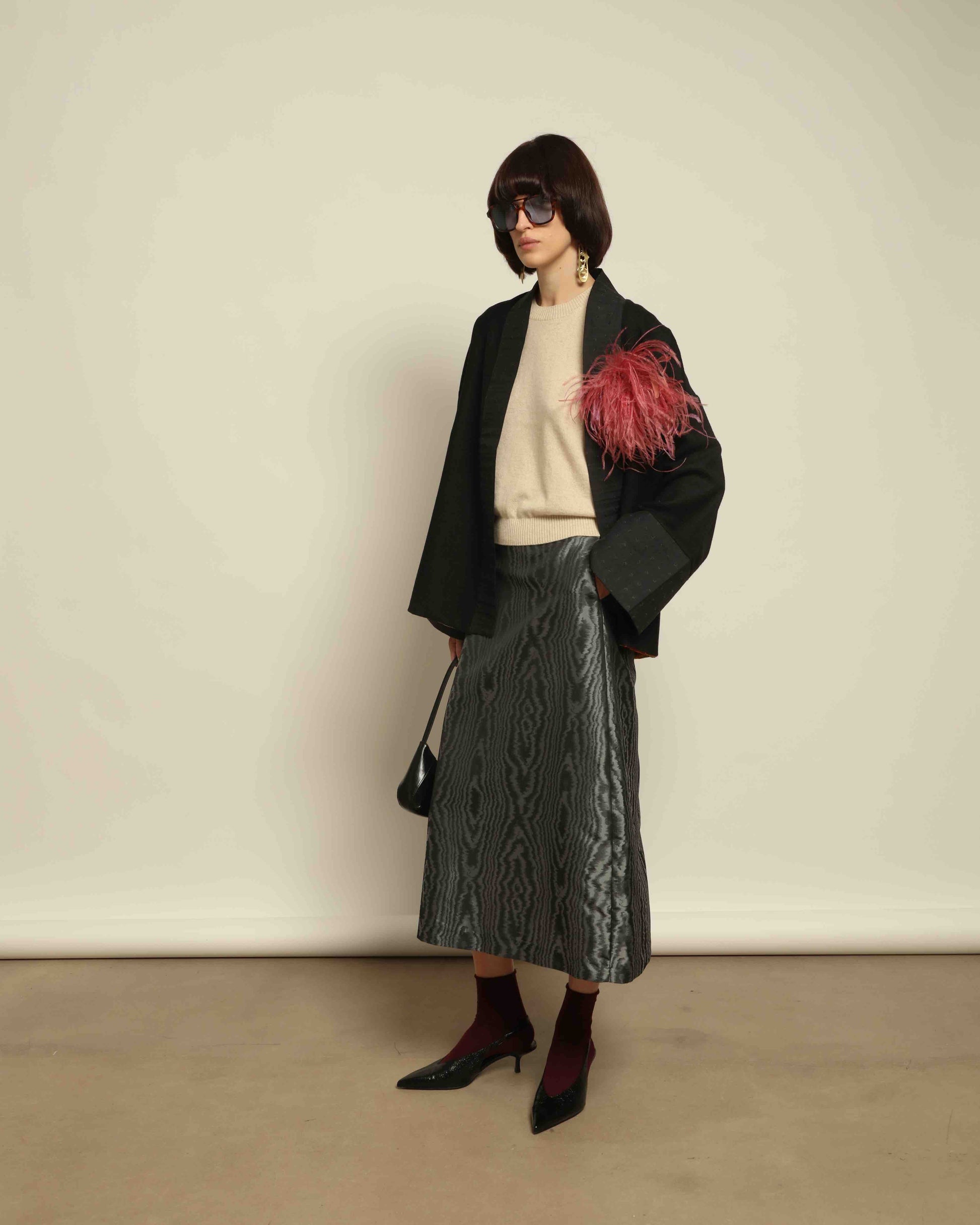 The model is wearing the Obidi Midnight Kantha Jacket in pure black, made of wool with a silk collar and Kantha silk lining, a timeless and versatile piece.