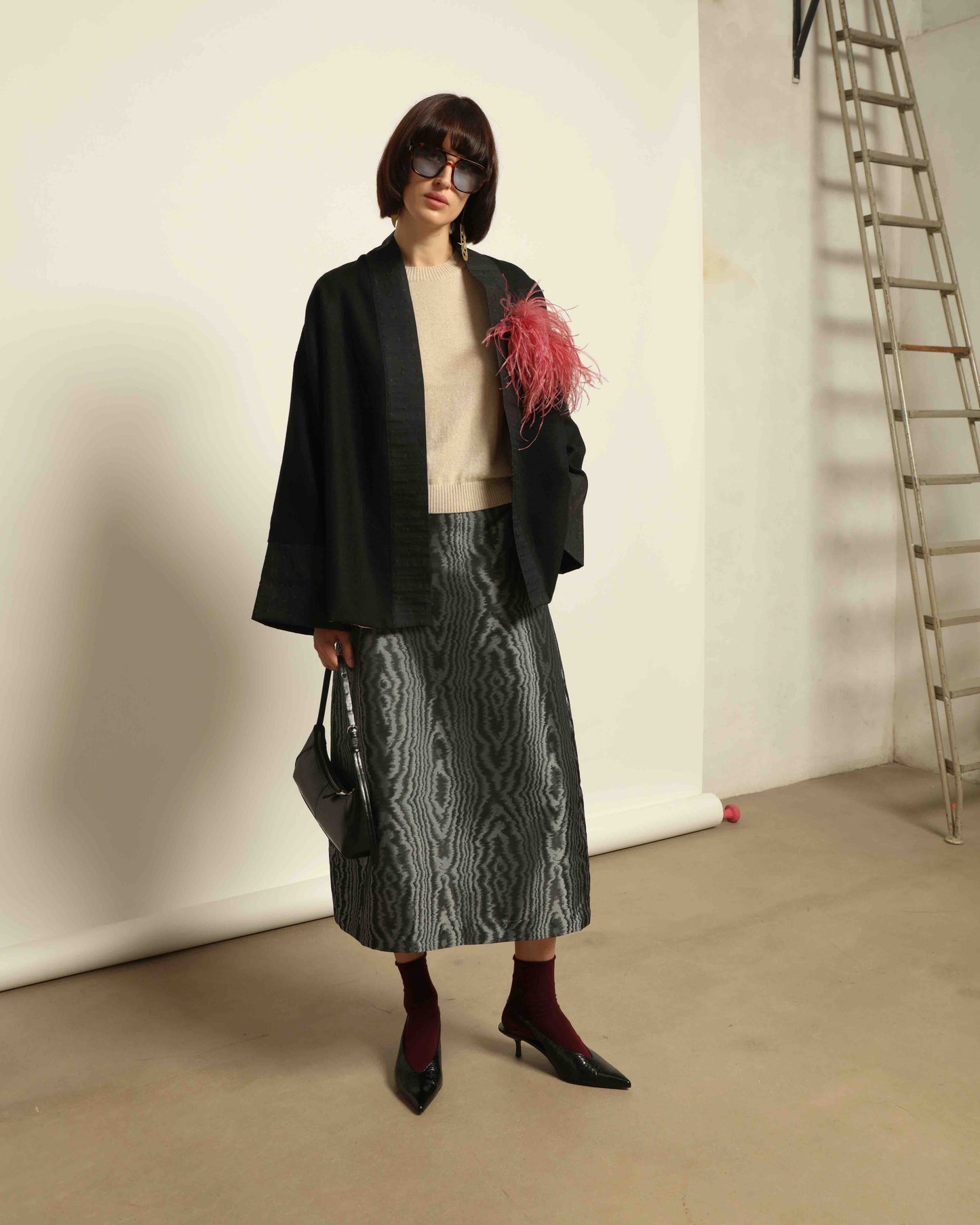 The model is wearing the Obidi Midnight Kantha Jacket in pure black, made of wool with a silk collar and Kantha silk lining, a timeless and versatile piece.