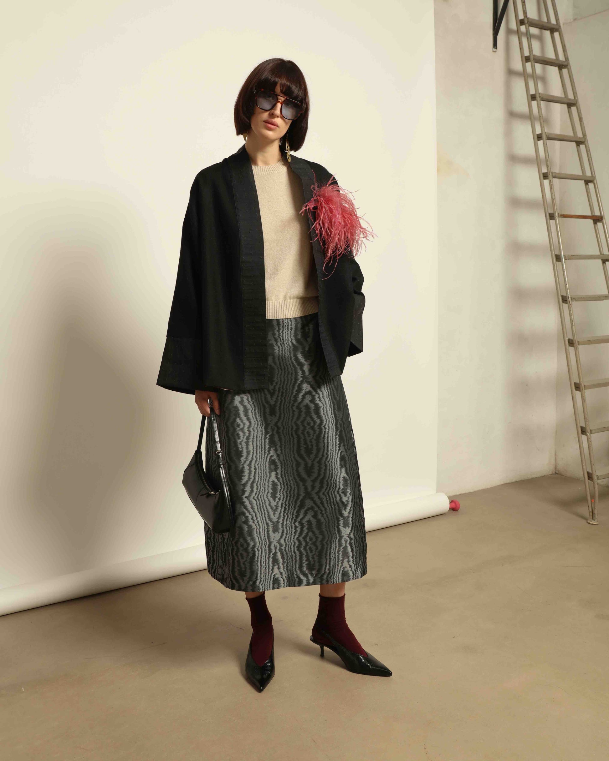 The model is wearing the Obidi Midnight Kantha Jacket in pure black, made of wool with a silk collar and Kantha silk lining, a timeless and versatile piece.