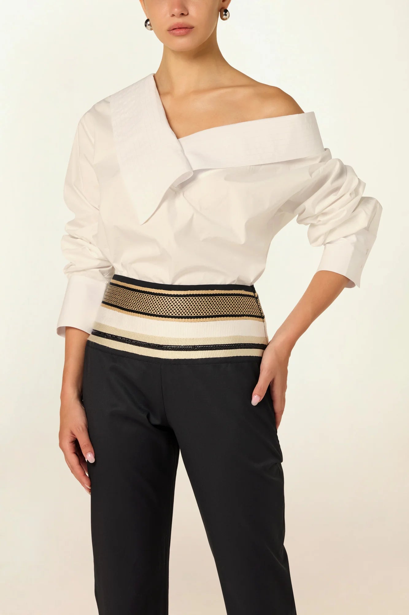 Model wearing a luxury off-shoulder woven cotton bodysuit by Abadia from the House of Nomad Stories collection featuring tailored stitching, structured fit and minimalist elegant design.