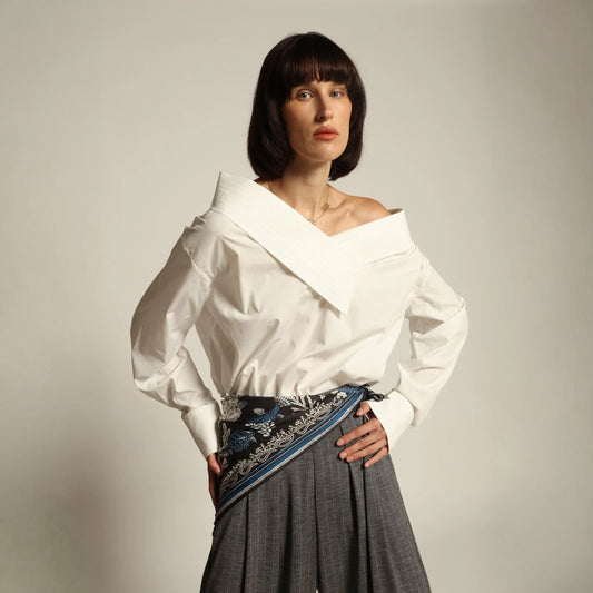 Model wearing a luxury off-shoulder woven cotton bodysuit by Abadia from the House of Nomad Stories collection featuring tailored stitching, structured fit and minimalist elegant design.