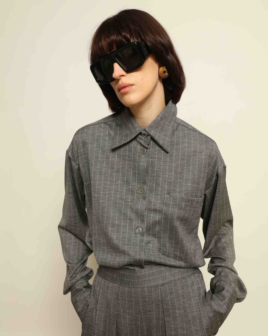 Model is wearing the Oscar Pinstriped Grey Jersey Shirt by House of Woven Stories, crafted in Italy from a merino wool and silk blend with subtle grey stripes and a tailored silhouette.