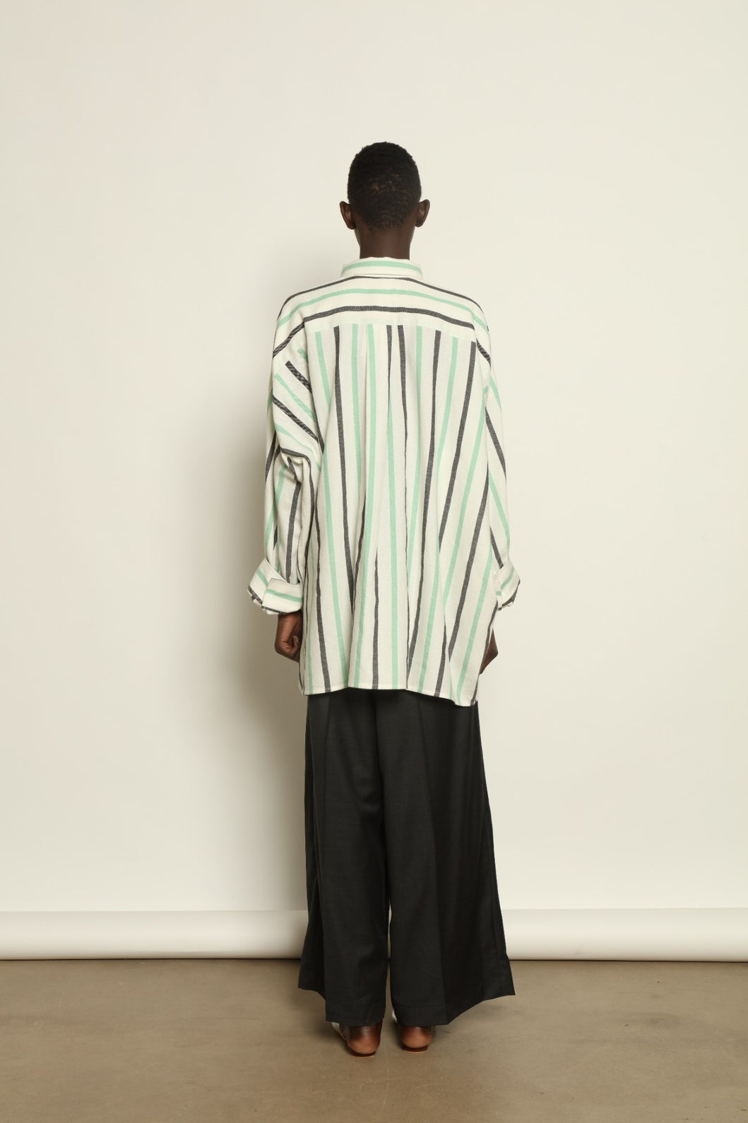 Model is wearing the Oversized Shirt with Collar by Marrakshi Life, part of House of Nomad Stories collection, handwoven cotton shirt with relaxed architectural fit, structured collar, and versatile styling