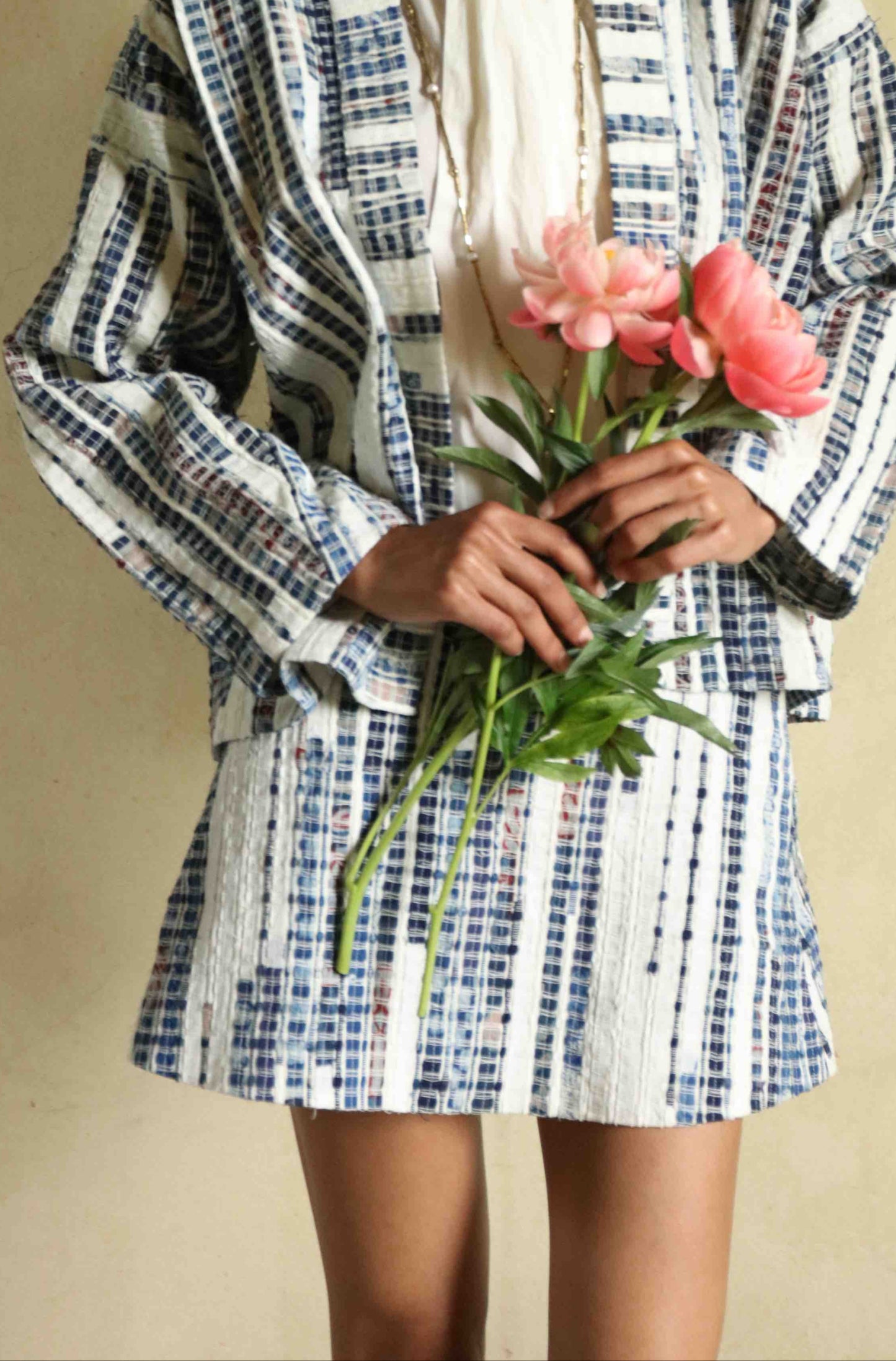 Handwoven mini skirt in upcycled blue and white cotton fabric with voile lining. Sustainable, eco-friendly fashion by Paiwand. Artisan-crafted, ethical clothing with unique texture. Matching kimono available. Part of House of Woven Stories curated collection.