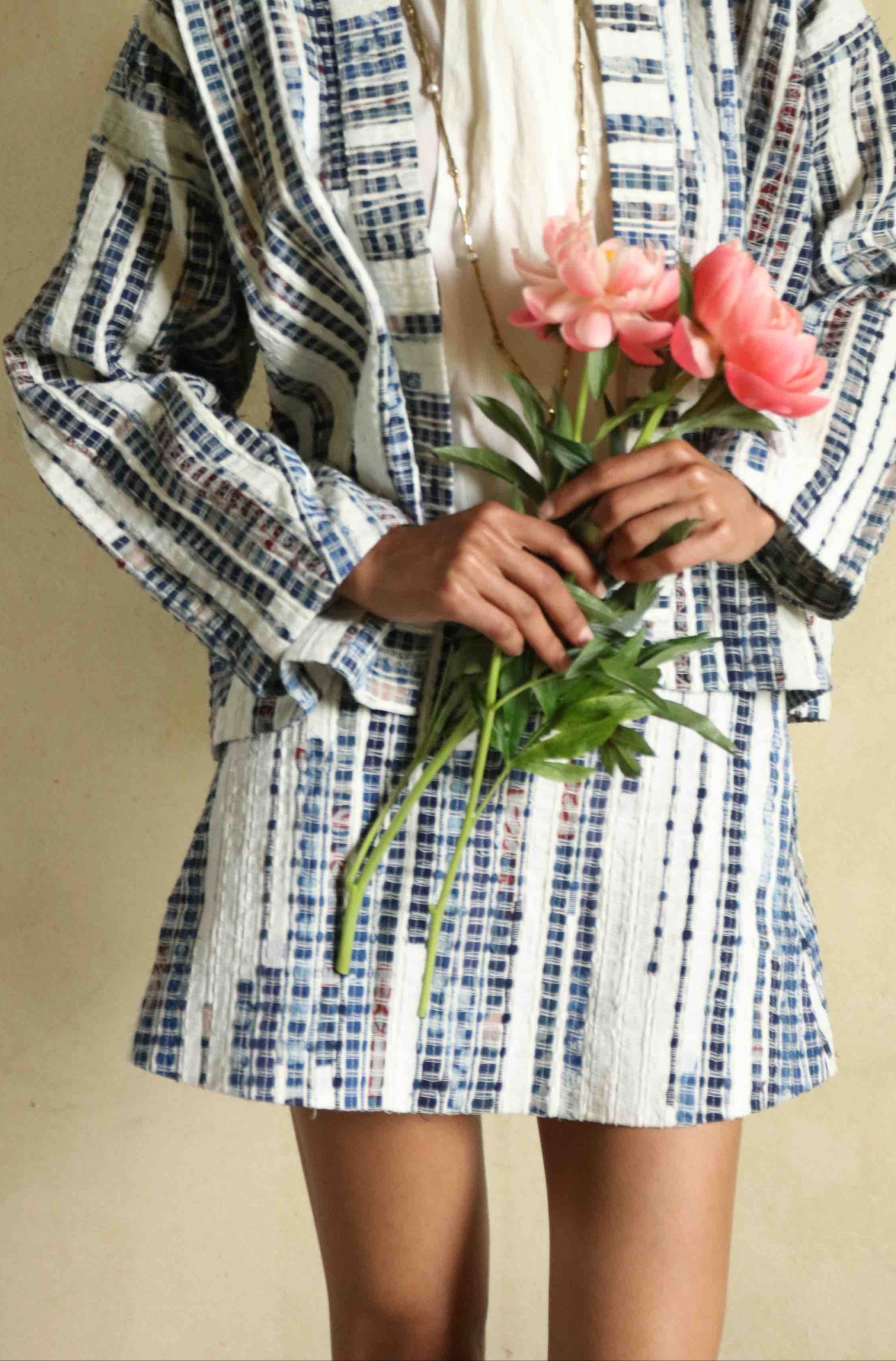 Handwoven mini skirt in upcycled blue and white cotton fabric with voile lining. Sustainable, eco-friendly fashion by Paiwand. Artisan-crafted, ethical clothing with unique texture. Matching kimono available. Part of House of Woven Stories curated collection.