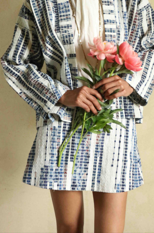 Handwoven mini skirt in upcycled blue and white cotton fabric with voile lining. Sustainable, eco-friendly fashion by Paiwand. Artisan-crafted, ethical clothing with unique texture. Matching kimono available. Part of House of Woven Stories curated collection.