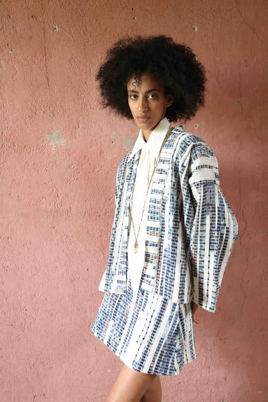 Handwoven from upcycled blue and white fabric waste, this lightweight kimono by Paiwand features a soft, textured finish and celebrates the beauty of conscious craftsmanship and subtle imperfections. Part of House of Woven Stories selection.