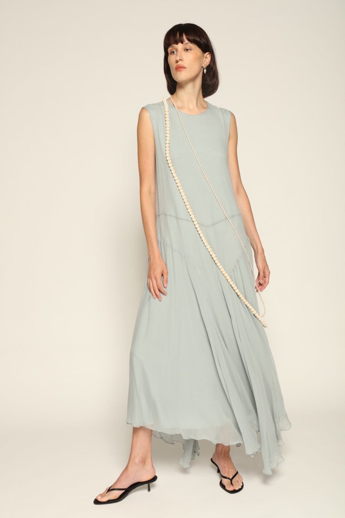 Model wearing a blue Panelled Dress by Abadia from the House of Nomad Stories collection, featuring a sleeveless midi silhouette, round neckline, and structured waist panel detailing with a minimal elegant finish.