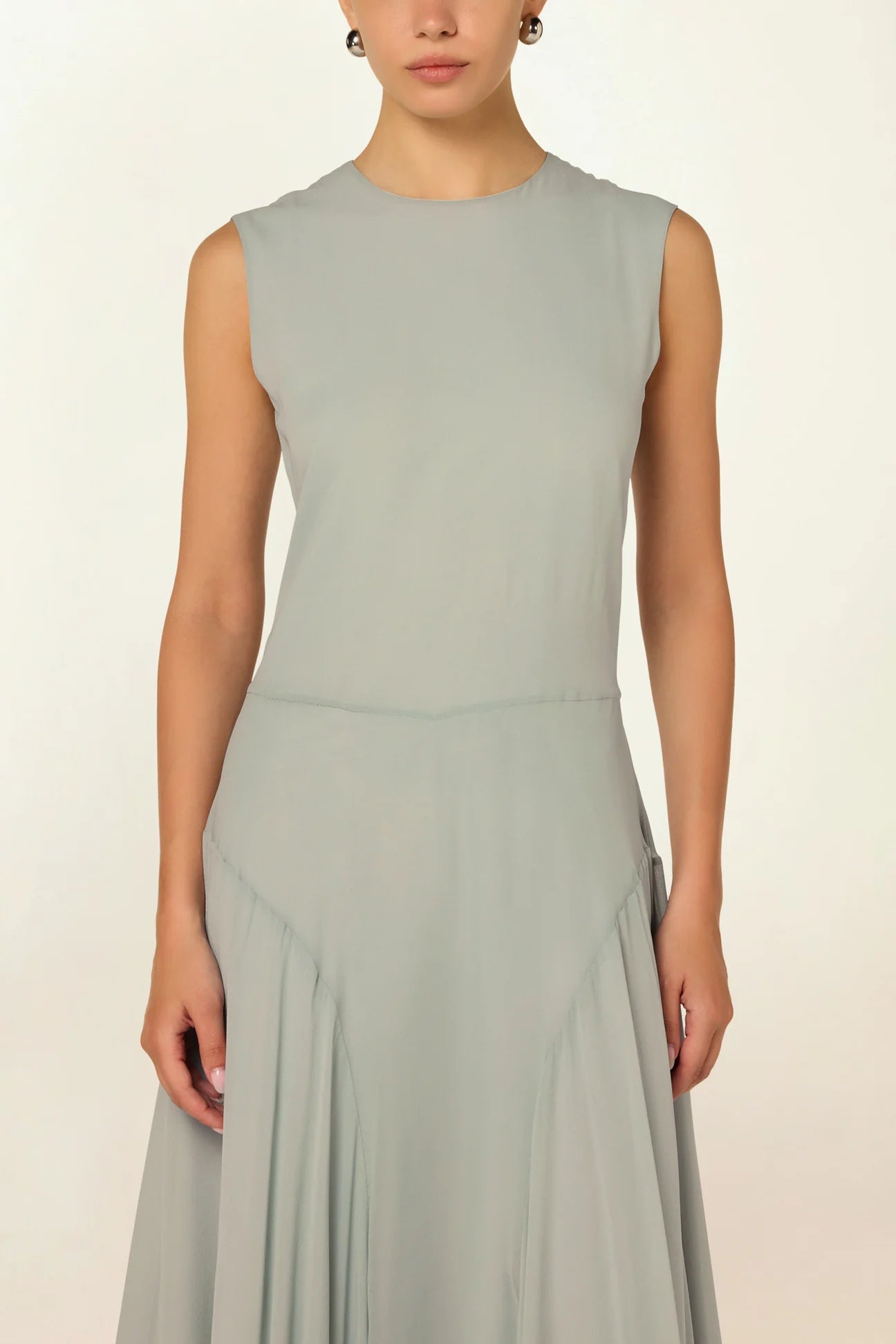 Model wearing a blue Panelled Dress by Abadia from the House of Nomad Stories collection, featuring a sleeveless midi silhouette, round neckline, and structured waist panel detailing with a minimal elegant finish.