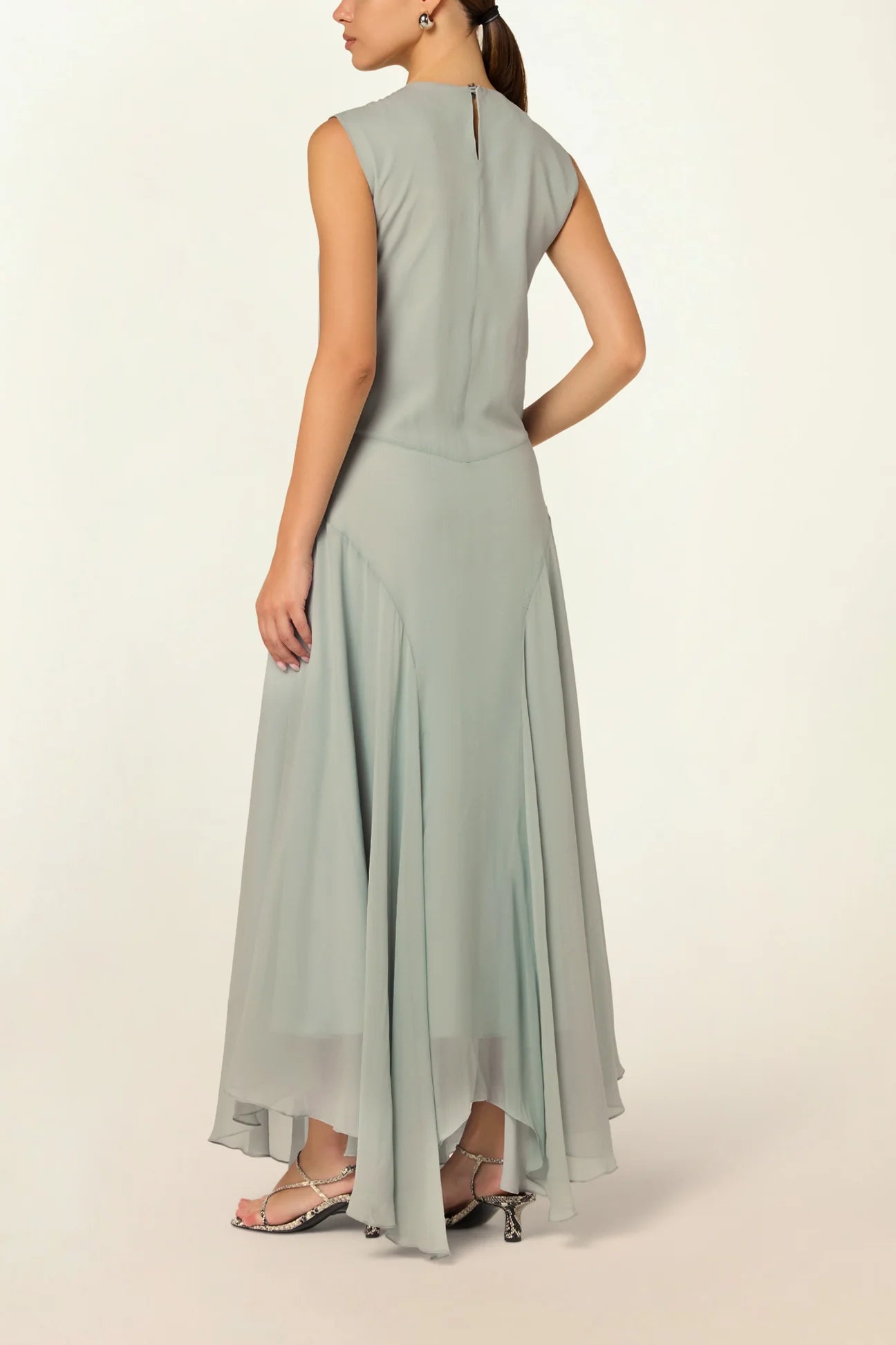 Model wearing a blue Panelled Dress by Abadia from the House of Nomad Stories collection, featuring a sleeveless midi silhouette, round neckline, and structured waist panel detailing with a minimal elegant finish.