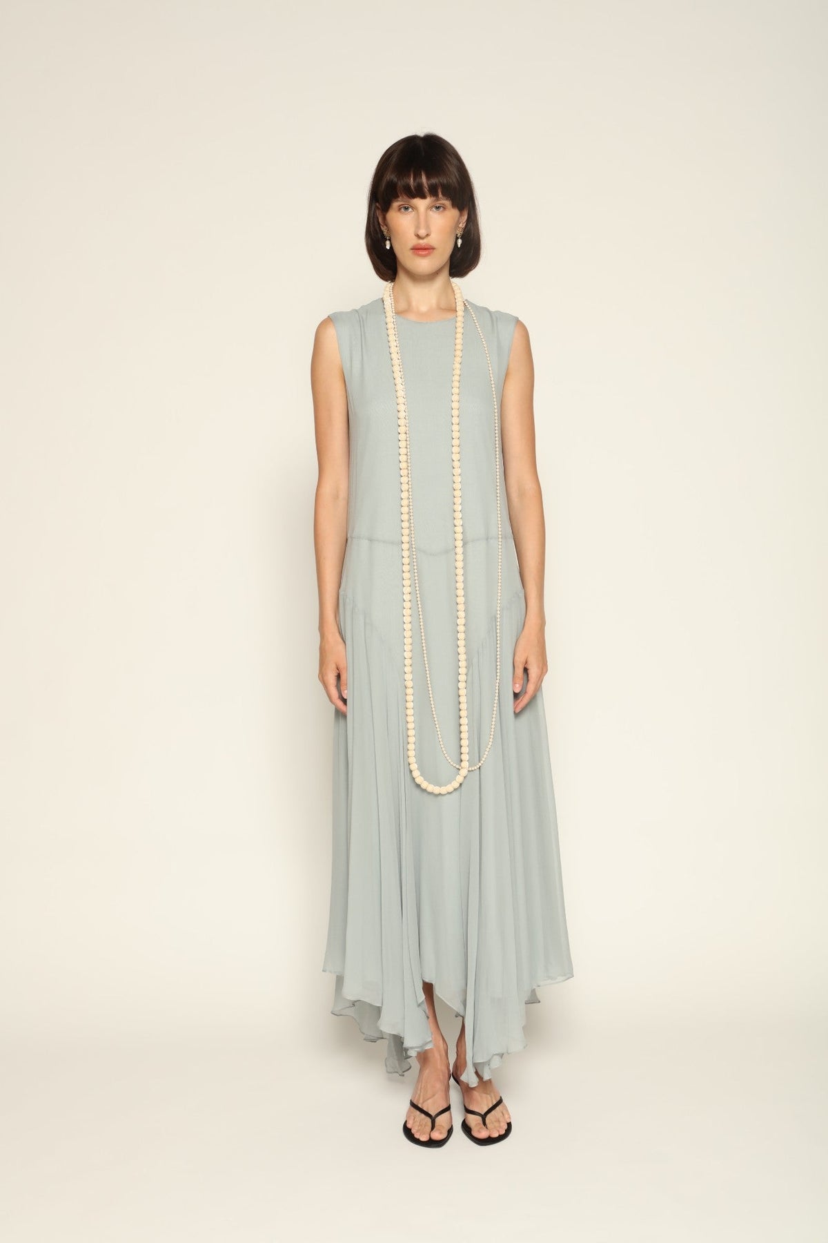 Model wearing a blue Panelled Dress by Abadia from the House of Nomad Stories collection, featuring a sleeveless midi silhouette, round neckline, and structured waist panel detailing with a minimal elegant finish.